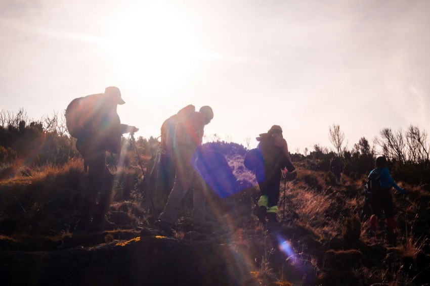 a group of people with backpacks walking on a dirt path