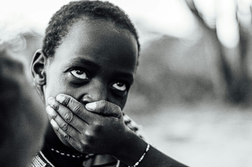 grayscale photo of woman covering her face with her hand