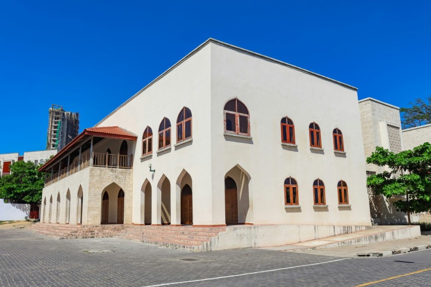 a large white building with arched windows on a sunny day