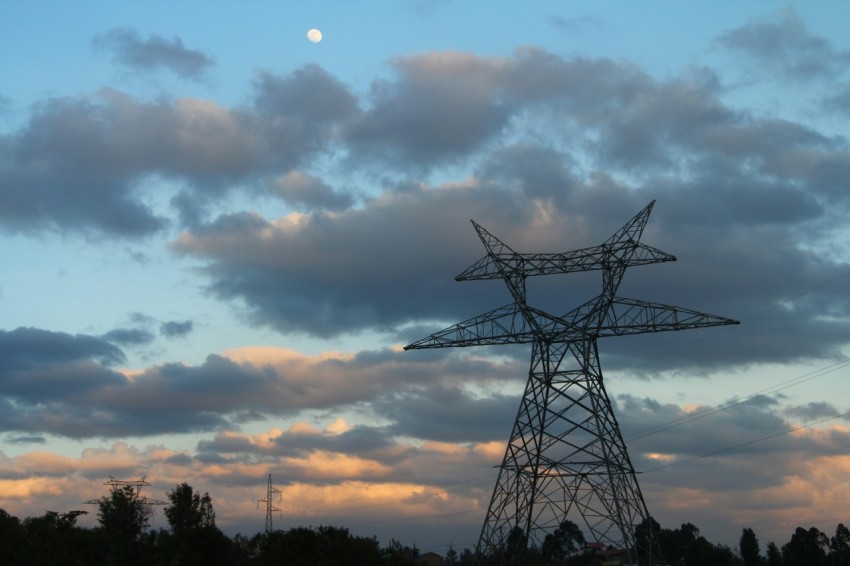 a high voltage power line with a full moon in the background