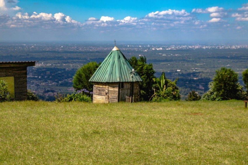 a small hut sitting on top of a lush green hillside