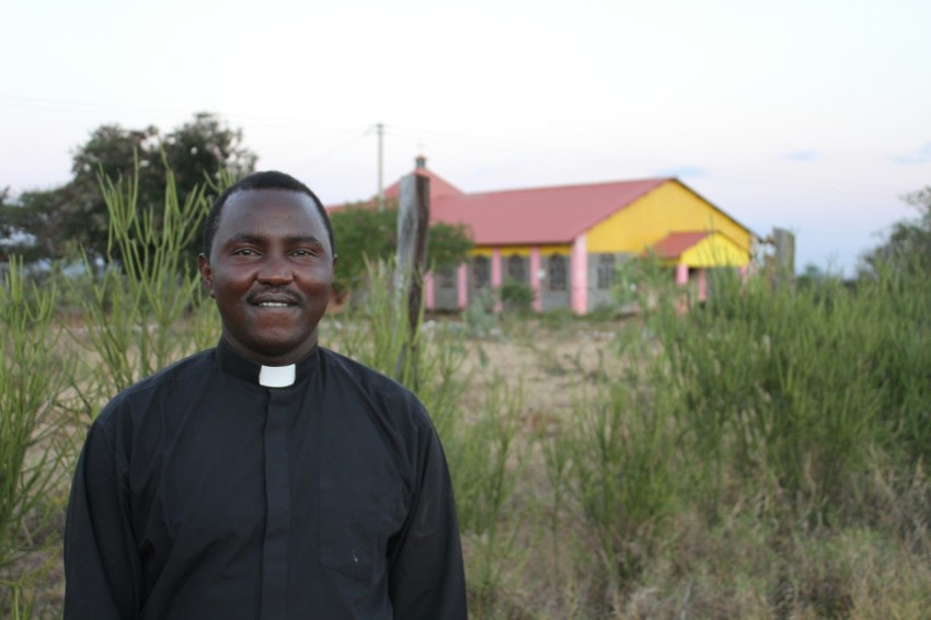 a man in a priests outfit standing in front of a house