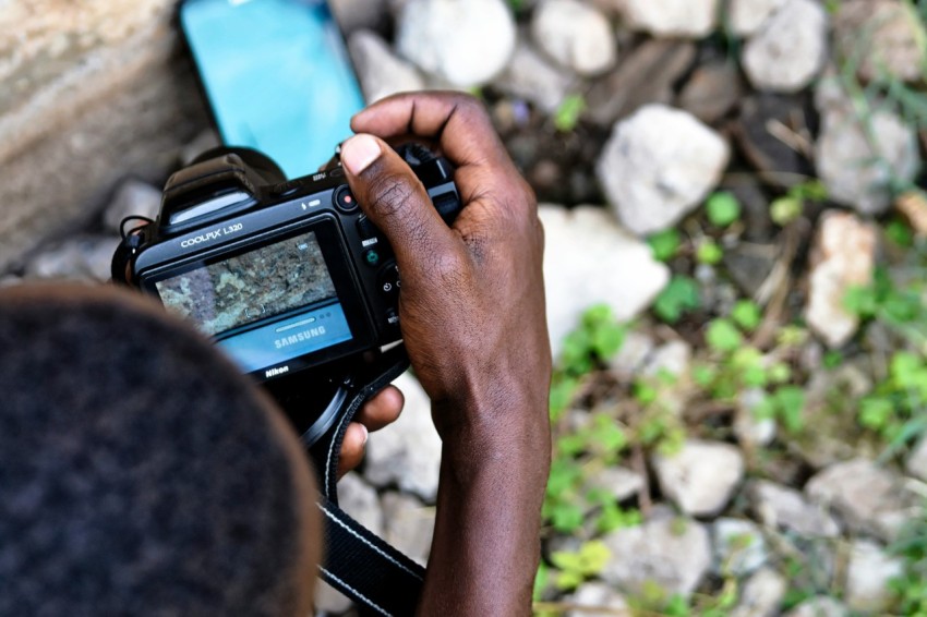 person taking a photo of samsung smartphone using dslr camera