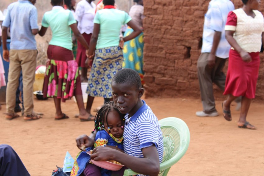 a man sitting on top of a green chair next to a little girl kI