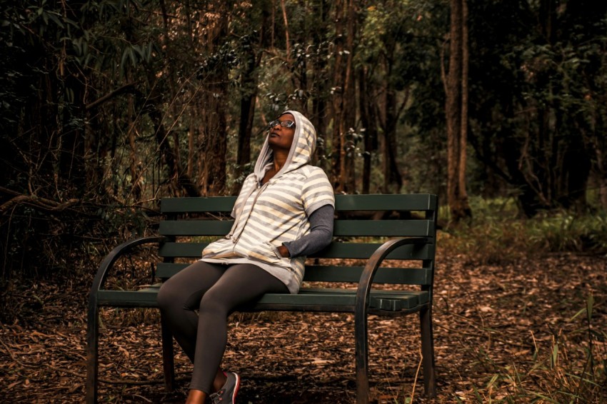 woman in white and brown hijab sitting on brown wooden bench