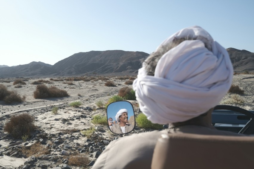 a man with a turban looking at a picture of himself in a mirror