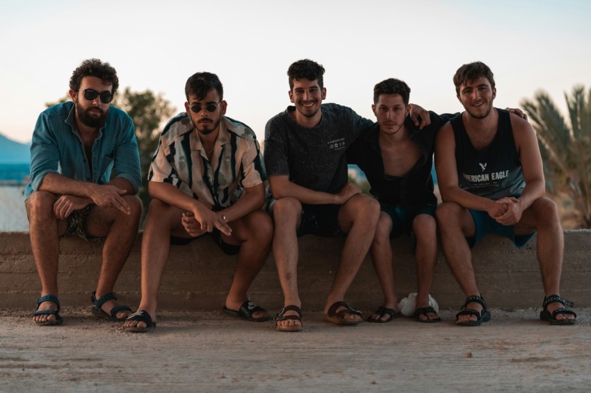 group of people sitting on brown sand during daytime