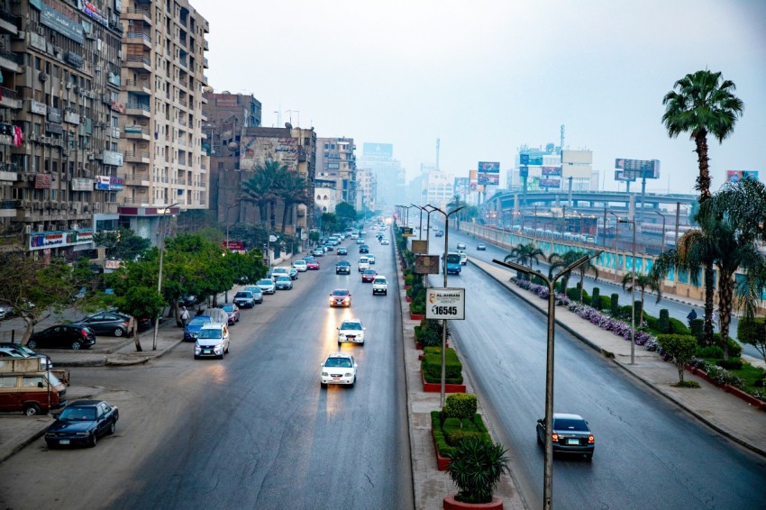 a city street filled with lots of traffic next to tall buildings 3u