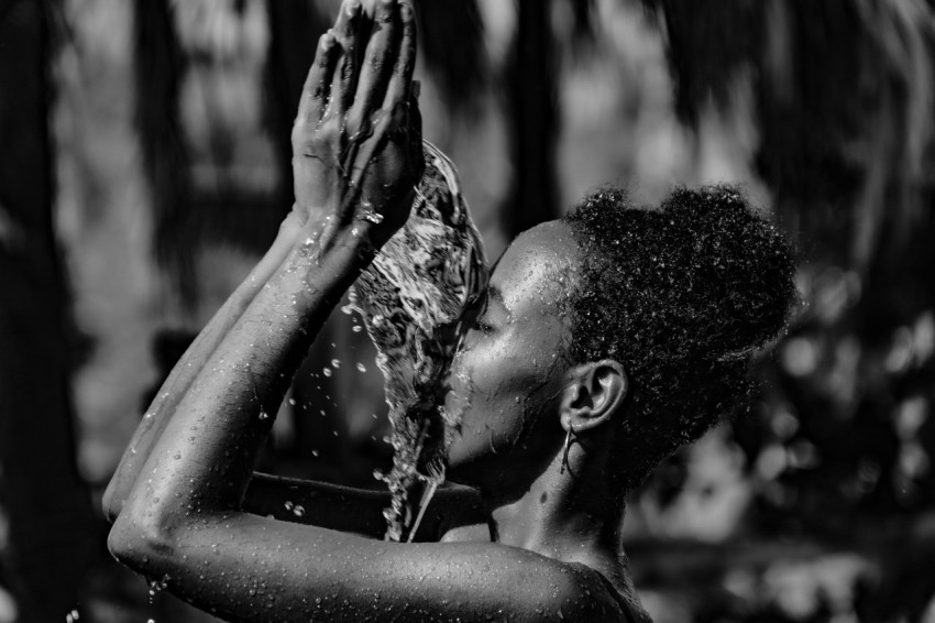 a black and white photo of a woman washing her hands