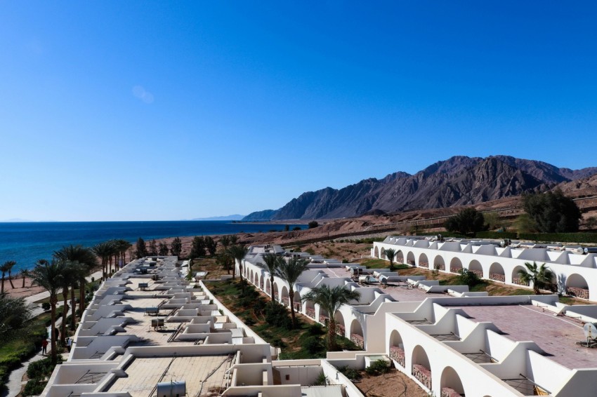 white concrete houses near body of water during daytime