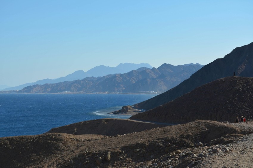 blue sea near mountain under blue sky during daytime