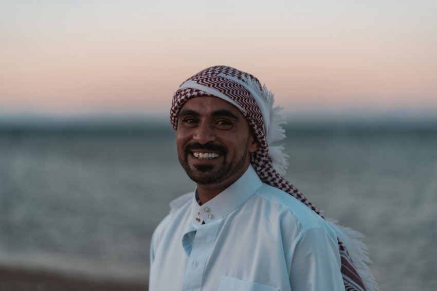 man in blue dress shirt wearing white and blue floral bandana