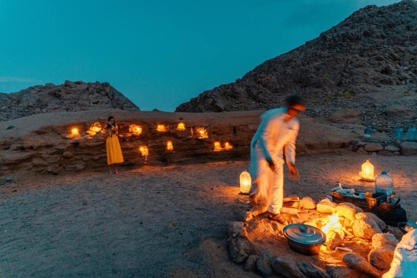 a man and woman standing next to a fire pit with a woman in the middle 4kQ_0uTvE