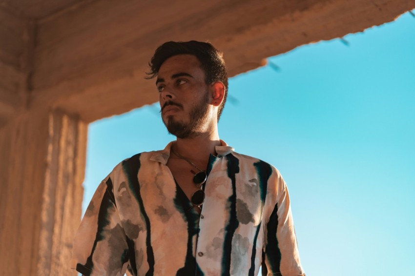 man in white and black button up shirt standing under blue sky during daytime eXYt0 cY8