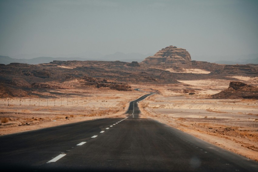 black asphalt road in the middle of brown mountains during daytime