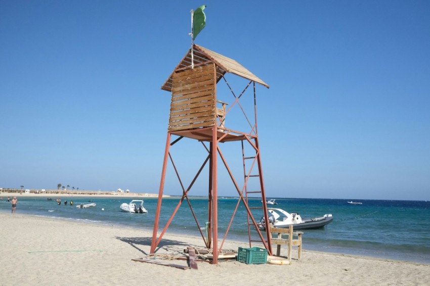 a lifeguard tower on a beach with a boat in the background