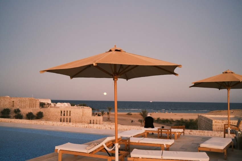 a couple of umbrellas sitting next to a swimming pool