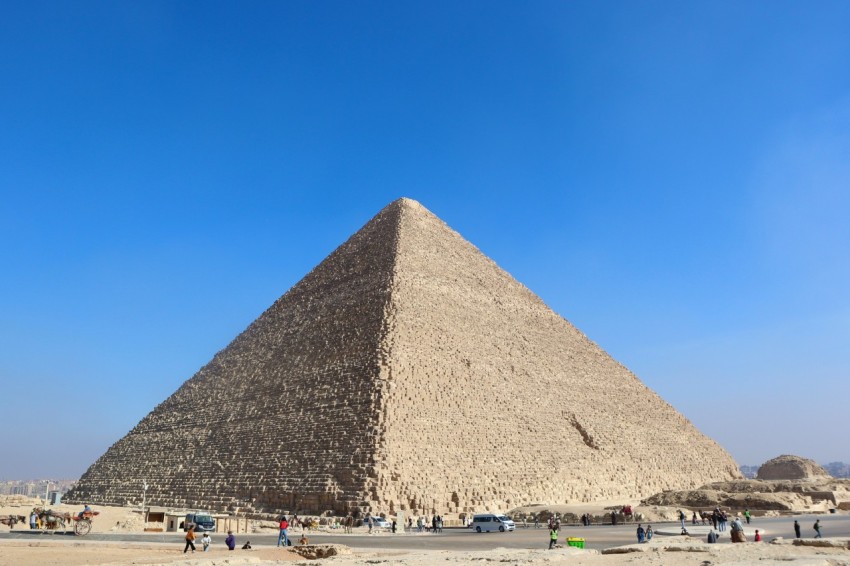 a group of people standing in front of a large pyramid