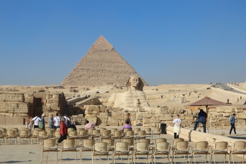 a group of people standing in front of a pyramid EW UK