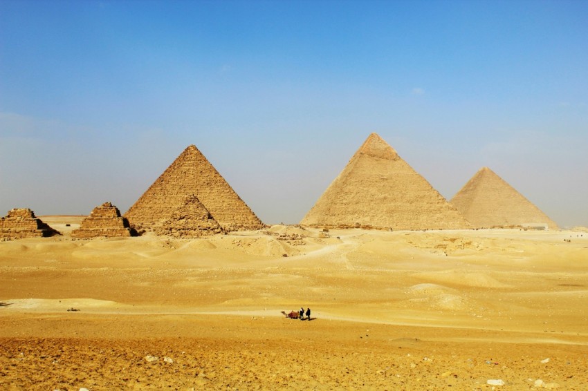 a group of pyramids in the desert with a sky background