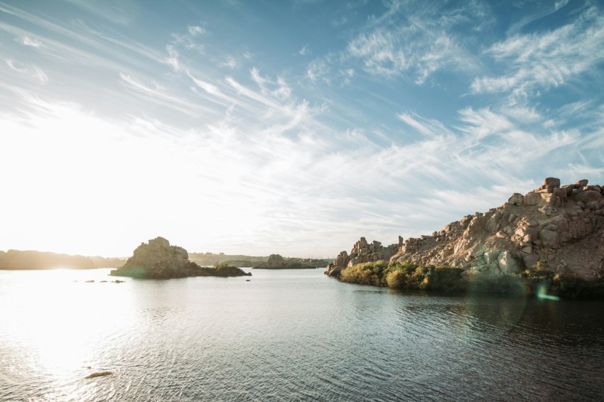 brown rock formation on body of water under blue sky during daytime _o