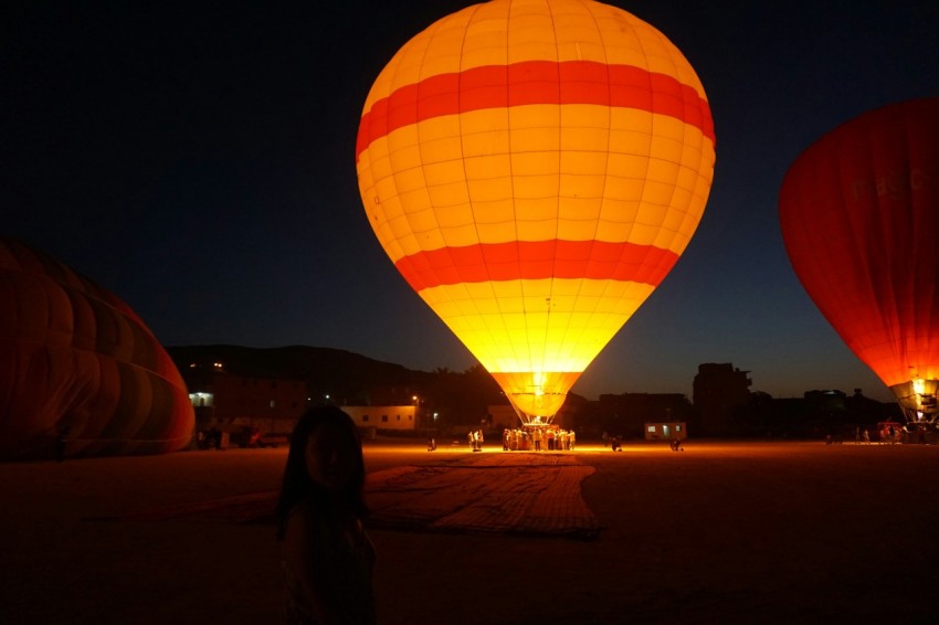 people standing near yellow red and blue hot air balloon during night time