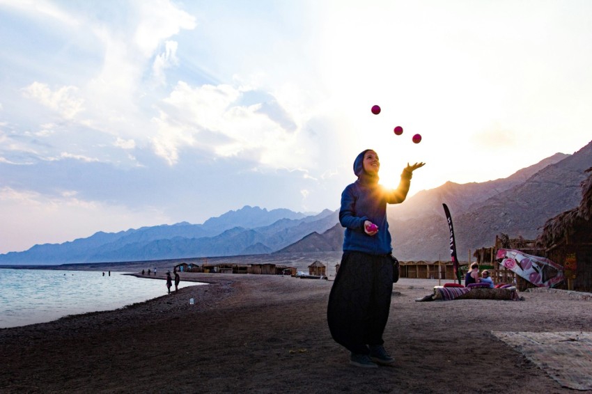 woman in green dress standing on beach during daytime FTFUli