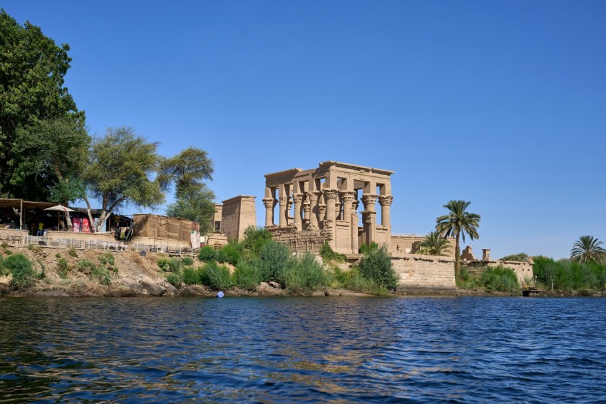 a large building sitting on top of a cliff next to a body of water