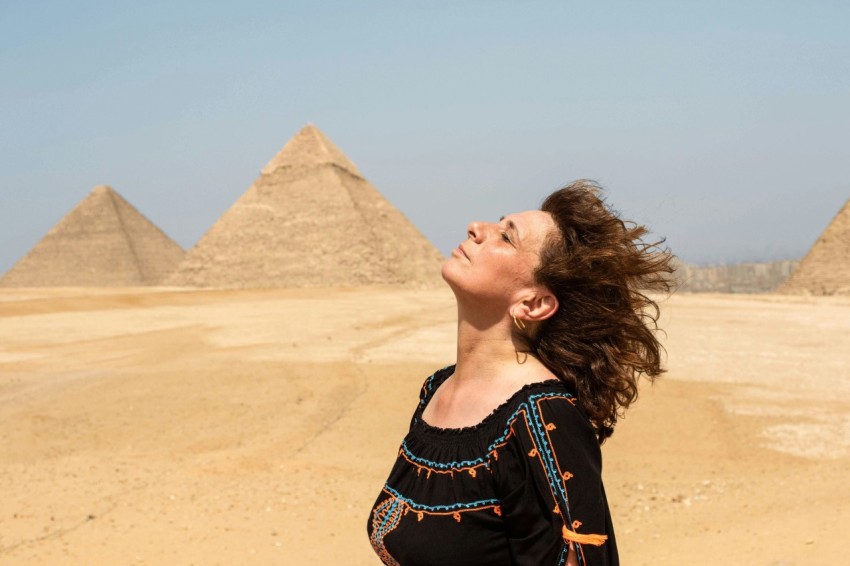 woman in black and blue crew neck shirt near pyramids