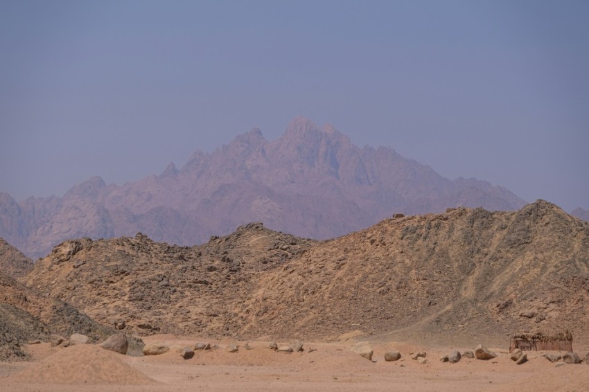 a desert landscape with a mountain in the background