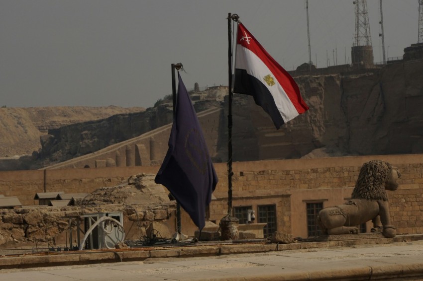 a statue of a person holding a flag in front of a building