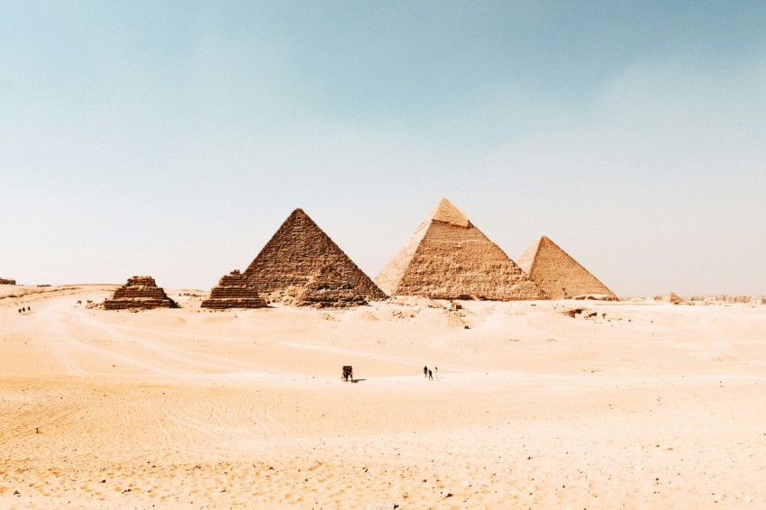 a group of pyramids in the desert with a sky background