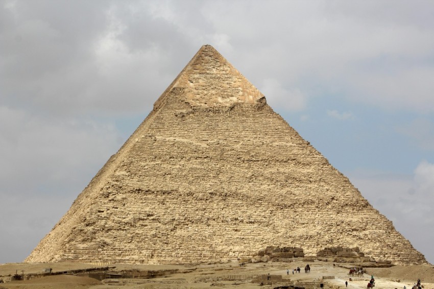 a group of people standing in front of a large pyramid