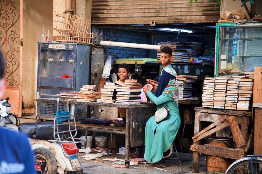 a group of people standing around a table with books on it