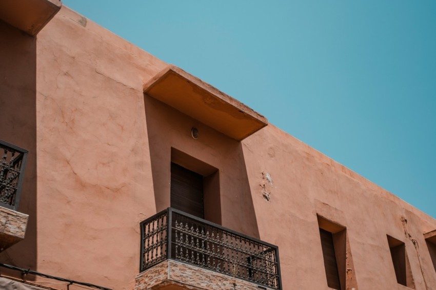 low angle photography of brown and black concrete building under blue sky