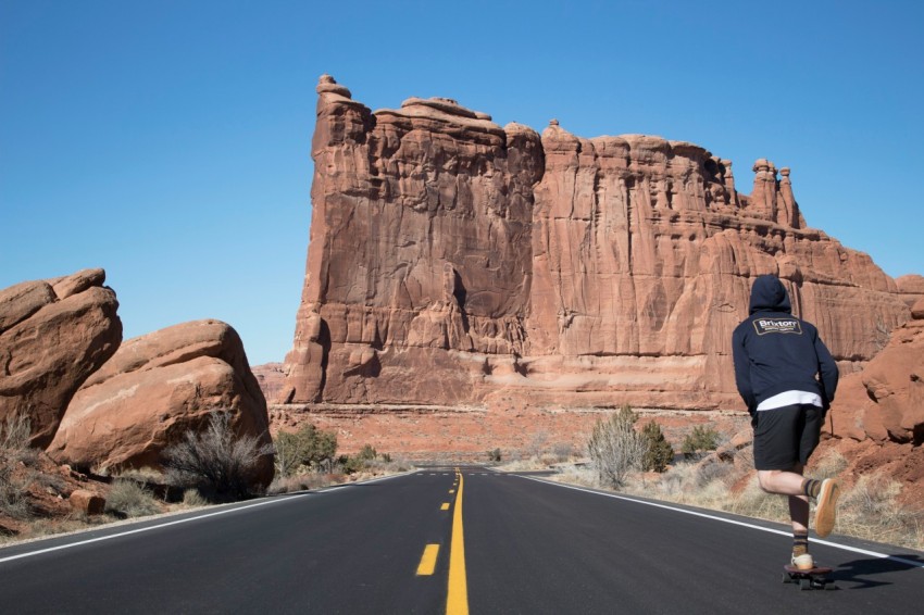 person in blue hoodie skateboarding near ruins le7azCA