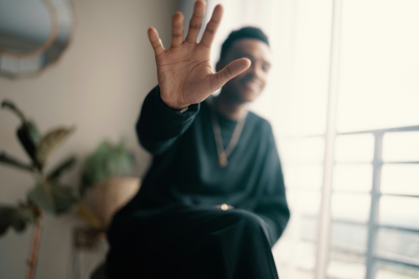 a man sitting in a chair with his hand up