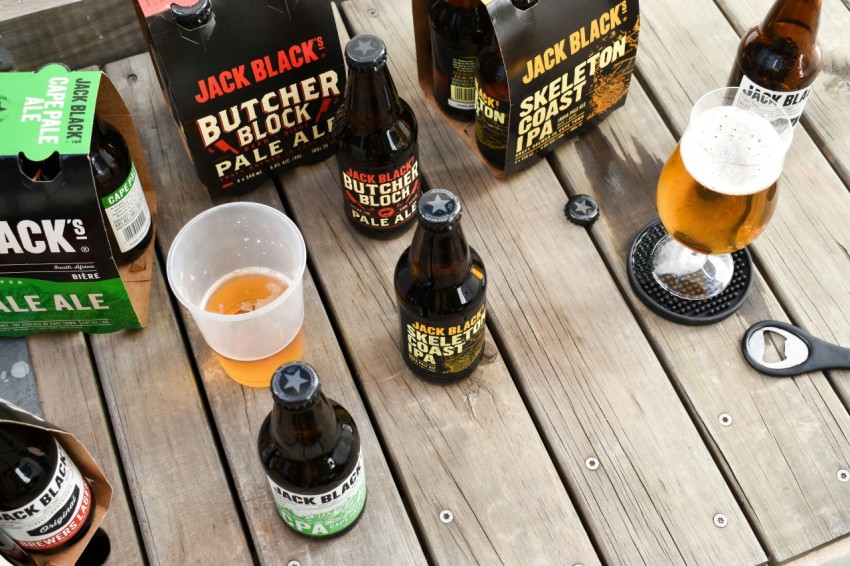 a wooden table topped with lots of bottles of beer