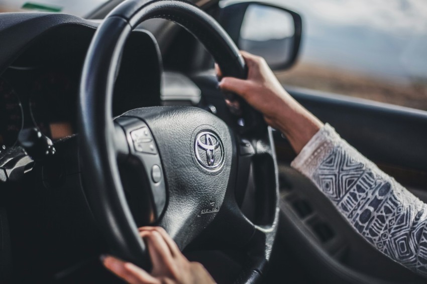 person holding black mercedes benz steering wheel