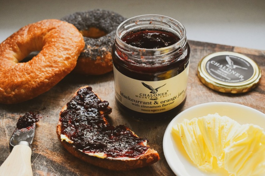 a wooden cutting board topped with a sandwich and jelly mUnrb7