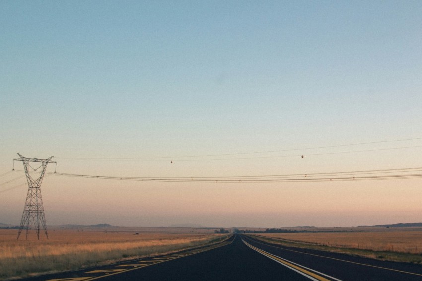 empty road between brown grass field during daytime