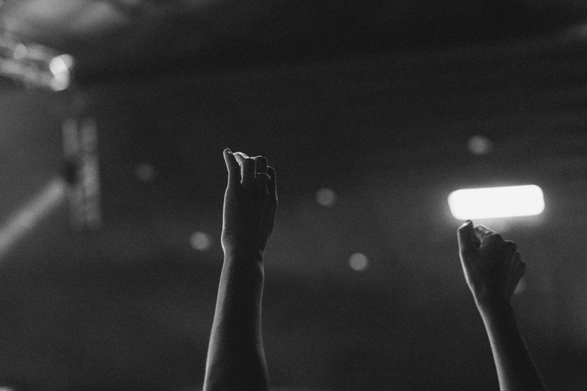 a black and white photo of a person raising their hands xs