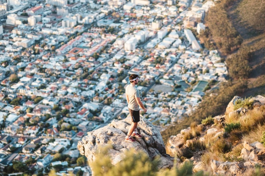 man standing near mountain cliff hL