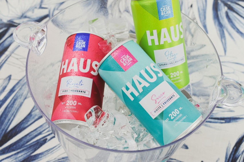 three cans of haus on ice in a glass bowl