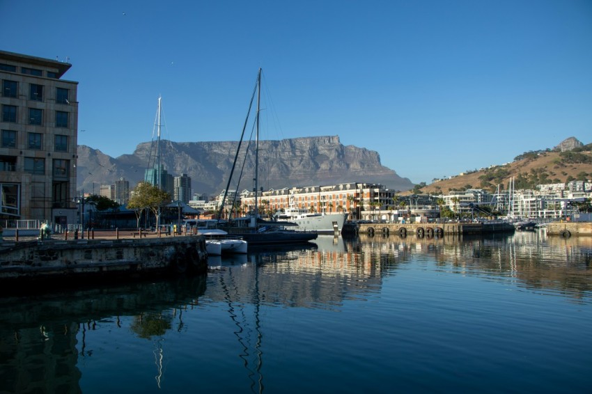 a group of boats docked in a harbor next to a mountain