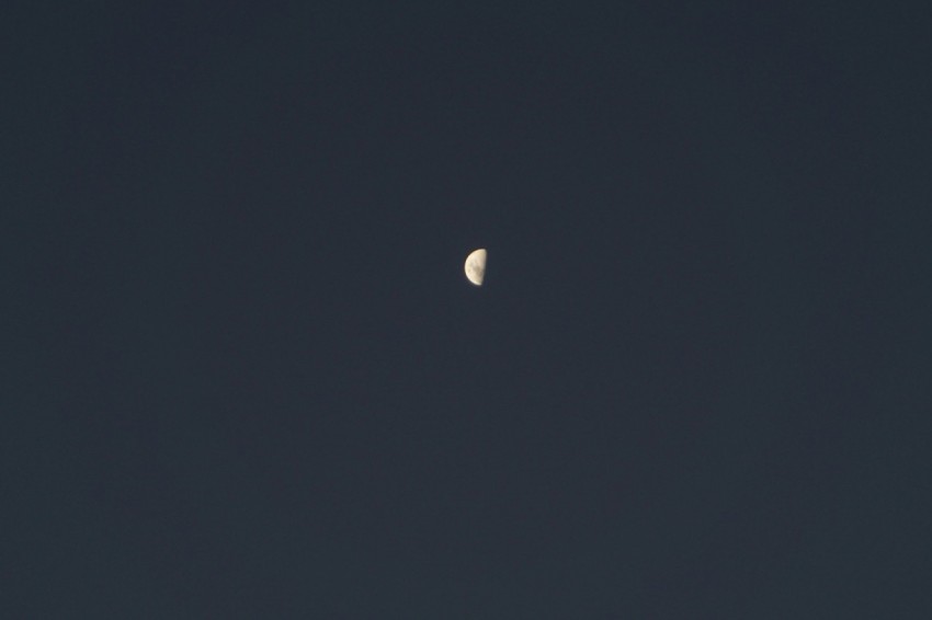 a half moon is seen in a dark sky