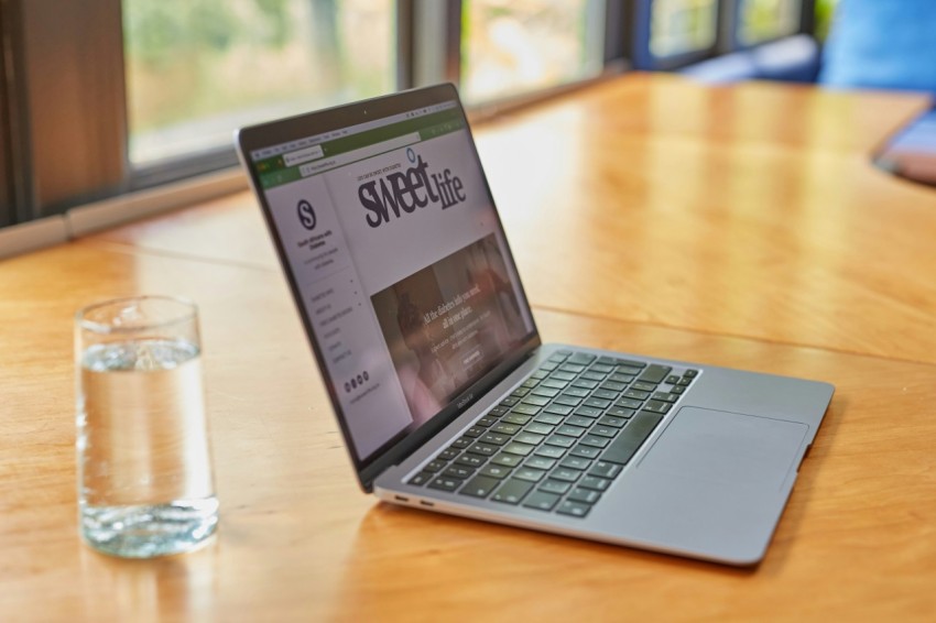 a laptop computer sitting on top of a wooden table