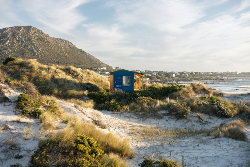 a small hut on a sandy beach near the ocean ODKzX