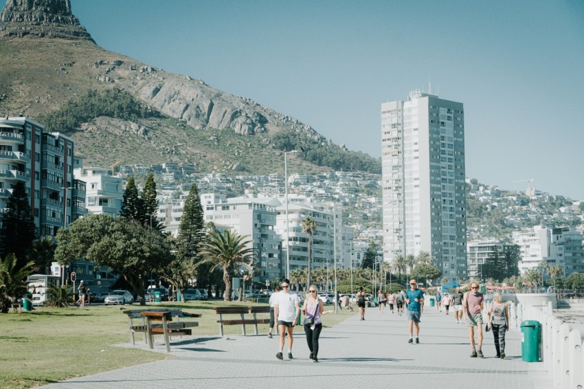 a group of people walking down a street next to tall buildings