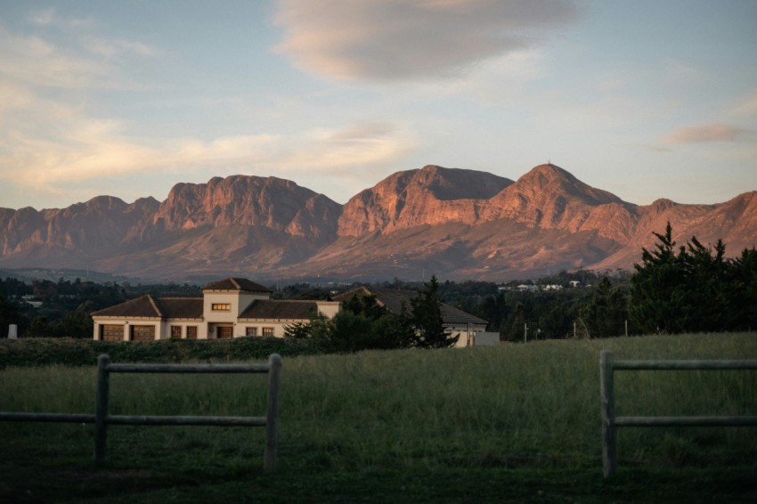 a house in a field with mountains in the background